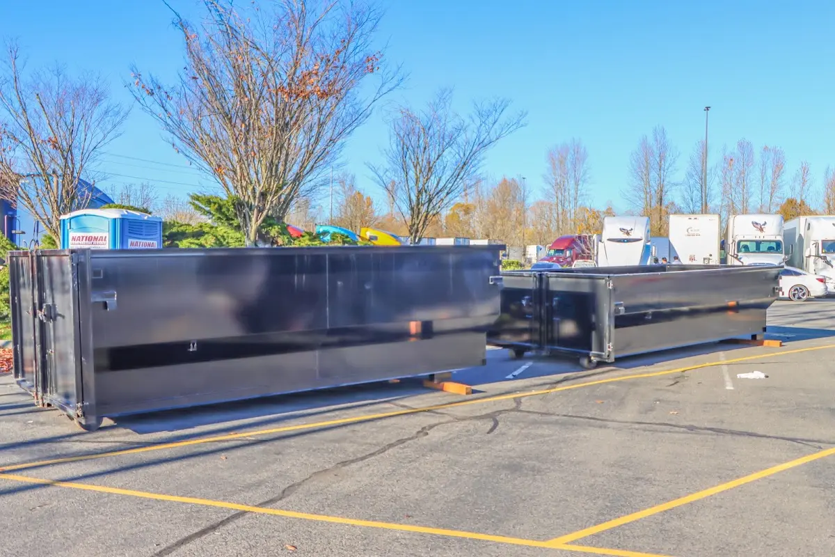 Professional dumpster rental service with roll-off container on residential driveway in Vail